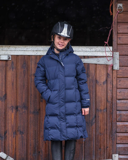Girl in EQUIDRY THORA Waterproof Riding Puffer Navy Jacket at Stables - Equestrian Fashion, Kids Riding Coat