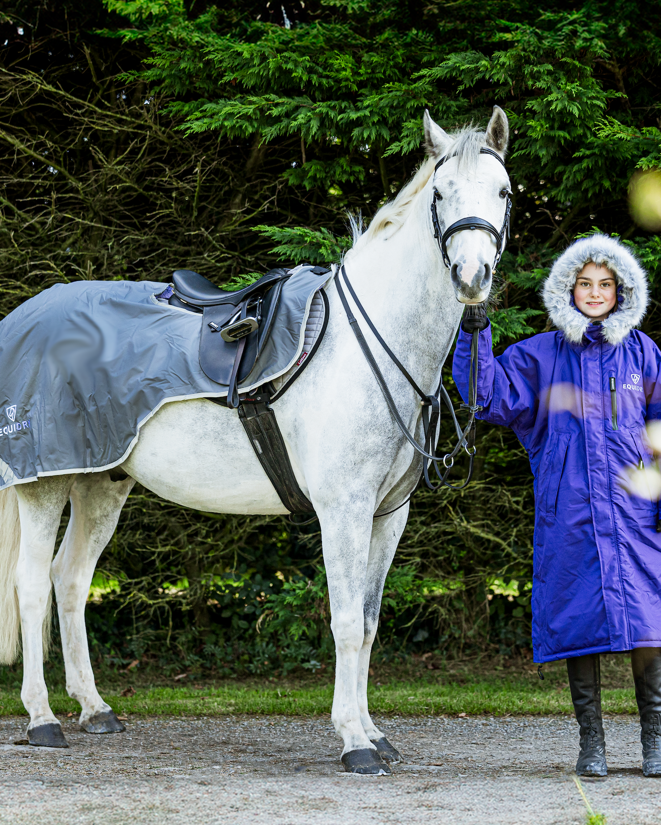 Equidry Girl in Waterproof Coat with Horse wearing Equiflair Exercise Sheet. Warm Grey Horse Riding Coat & Grey Exercise Sheet for Horses.