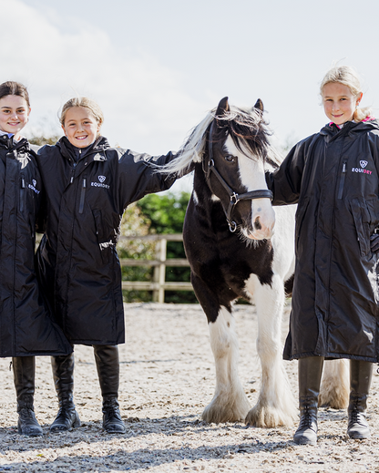Equidry Children's Riding Coats: Three kids with horse in black waterproof Equidry Evolution Thin Fleece equestrian apparel.