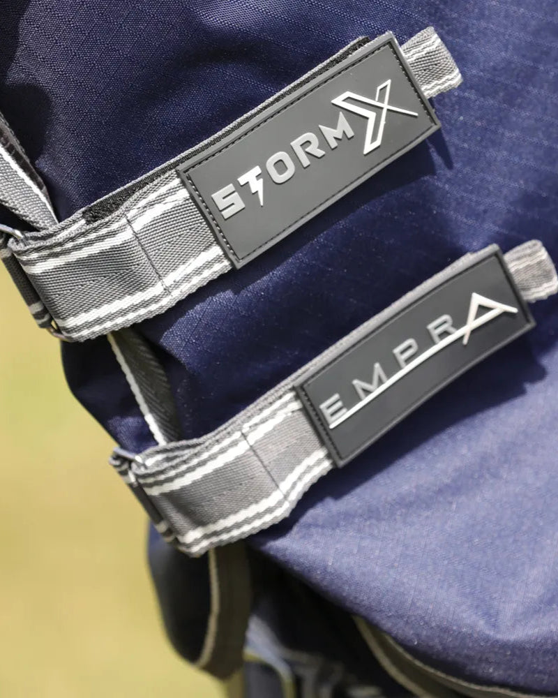 StormX Empra 100 Turnout Rug: Close-up of navy horse rug straps with StormX and Empra logos. Waterproof & durable equine protection.