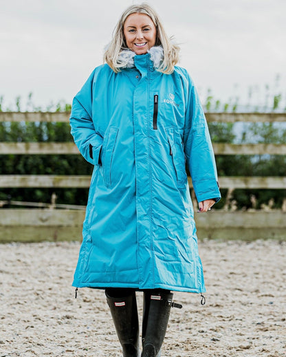EQUIDRY Evolution Lux Women's Warm Waterproof Winter Horse Riding Coat Thick Fleece Lining with Faux Fur Trim Hood in turquoise rider in arena
