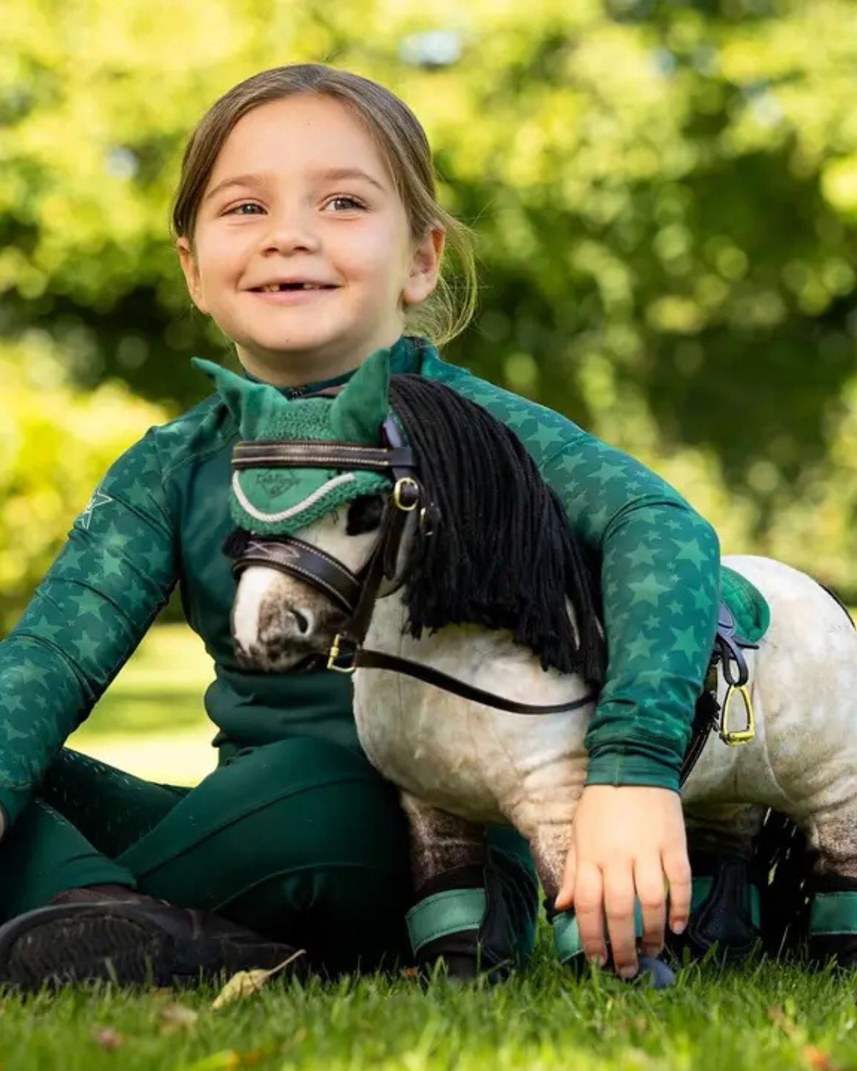 Girl with Lemieux Toy Pony Dream at Equiflair. Plush horse toy with plaitable mane and black tail. Educational toy for kids.