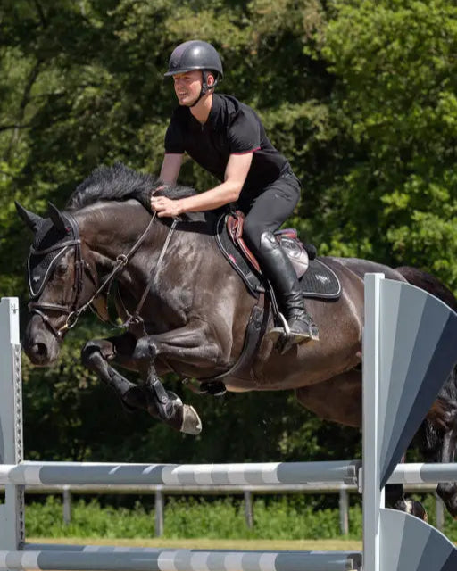 Equestrian: Man on jumping horse with LEMIEUX Puissance Suede Close Contact black Saddle Pad. Horse riding equipment by Equiflair.