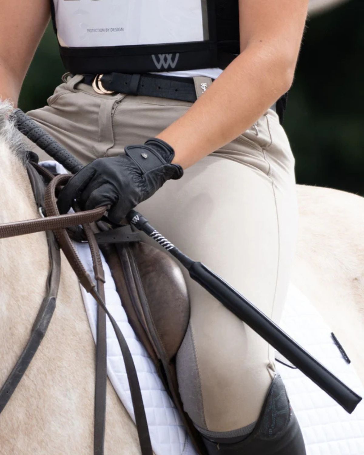Rider with Woof Wear Full Grip Jump Bat in Black. Equestrian gear, horse riding equipment.