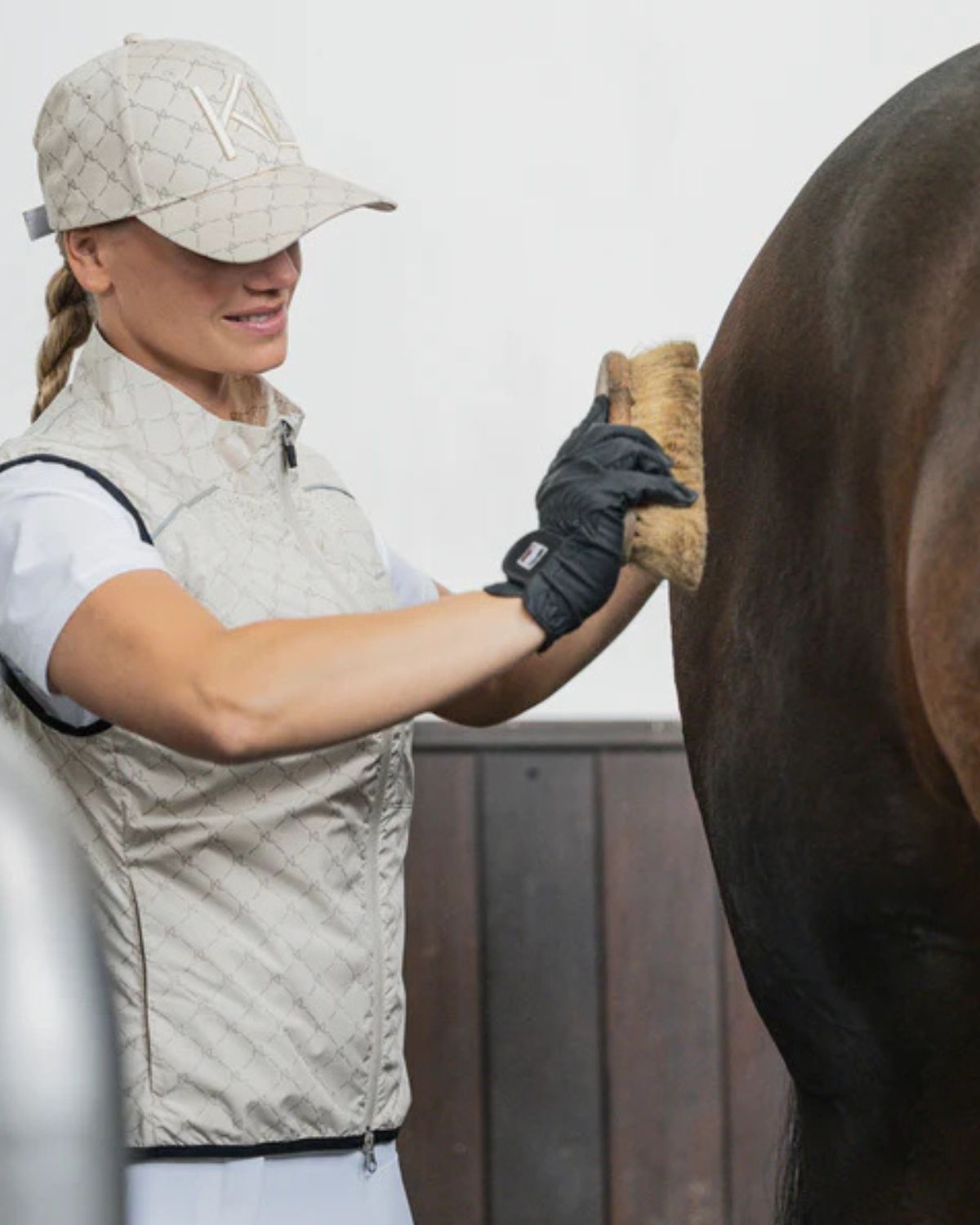 Kingsland bodywarmer: Woman grooming horse, equestrian fashion, riding apparel, beige vest, KL logo.