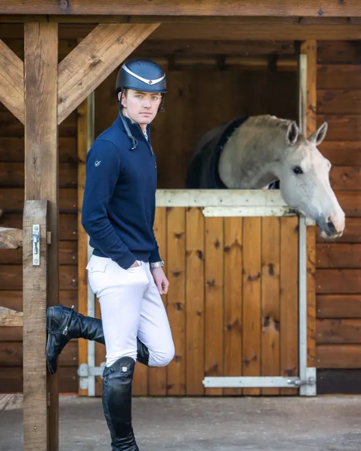 LeMieux Mens White Breeches: Stylish equestrian attire for horse riding. Man in riding gear with a horse in the background.