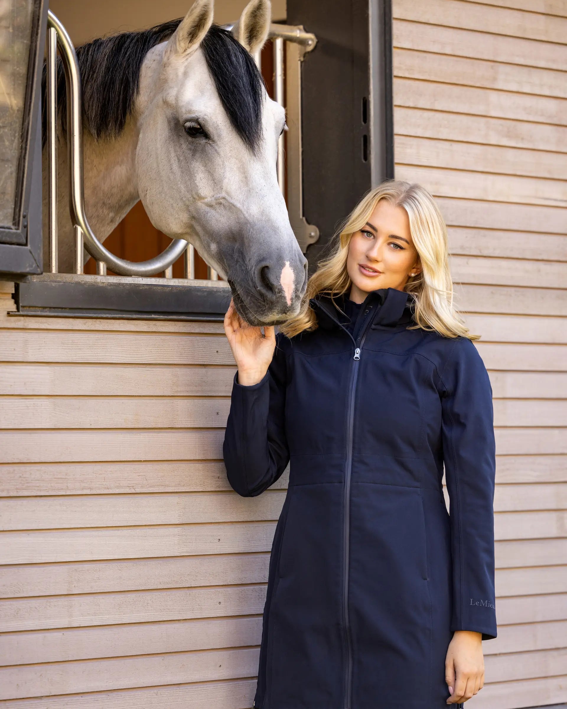 Woman in LEMIEUX Navy Riding Jacket with Horse - Lightweight & Water Resistant Equestrian Apparel