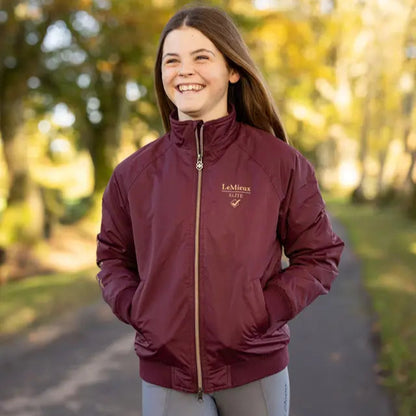 LeMieux Young Rider Elite Team Jacket Burgundy: Girls' equestrian style, waterproof & windproof outerwear for young riders.