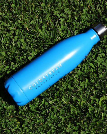 Coldstream Equestrian Blue Water Bottle on Grass. Equiflair Stainless Steel Insulated Drinkware.