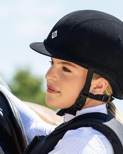 Girl in black Charles Owen YR8 junior riding helmet. Equestrian head protection.