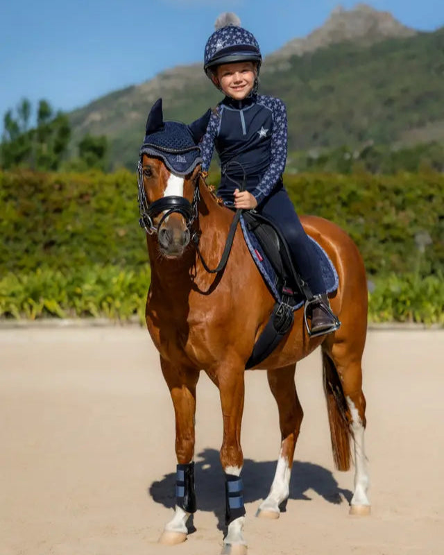 Young rider on horse in LEMIEUX MINI BASE LAYER INDIGO set from Equiflair.