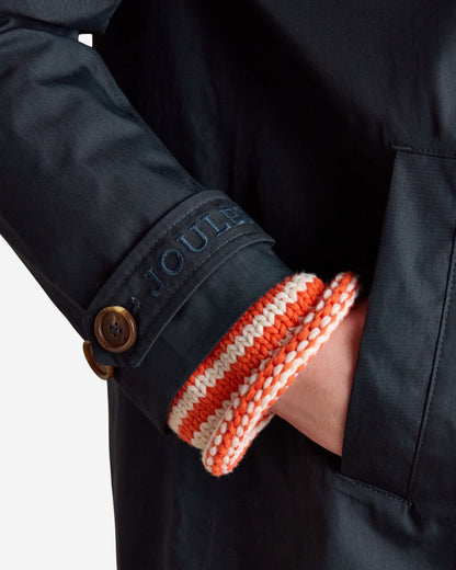 Joules Rainmore Navy Raincoat Sleeve Detail: Waterproof coat with button, sleeve cuff, and pocket featuring Joules branding.
