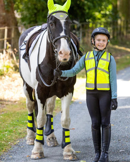 Young rider with horse wearing Woof Wear Hi Vis Yellow Riding Vest, promoting safety & visibility. #equestrian #horsebackriding