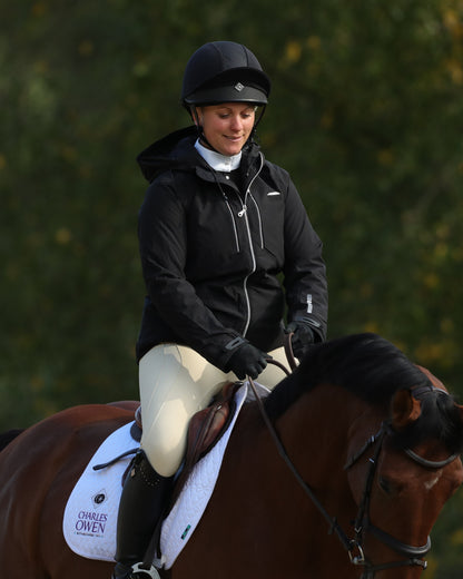 Equestrian rider wearing Charles Owen 4 Star jockey helmet on horseback. Secure and stylish head protection for horse riding.
