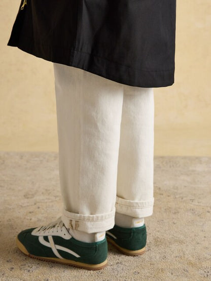 Joule Coat: Black Waterproof Coat with Hood, Green Sneakers, White Jeans