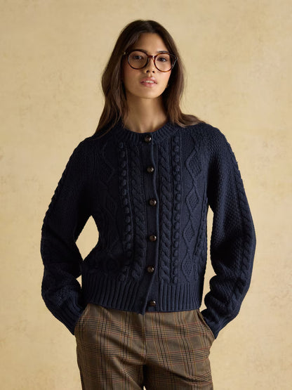 Woman in Navy Cable Knit Cardigan by Equiflair, textured wool sweater, button front, plaid pants