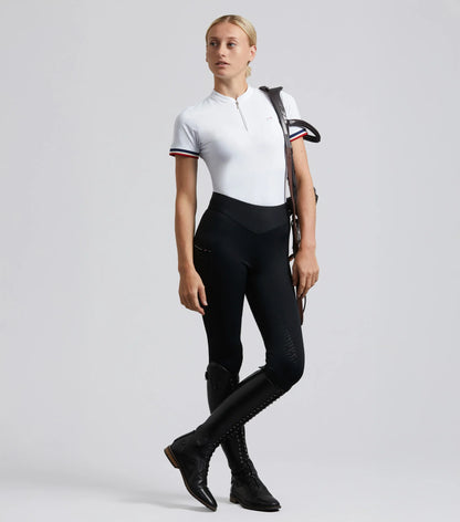 Woman in Premier Equine Aporia riding tights jet black equestrian apparel. Black riding pants, high waist, full seat silicone gel.
