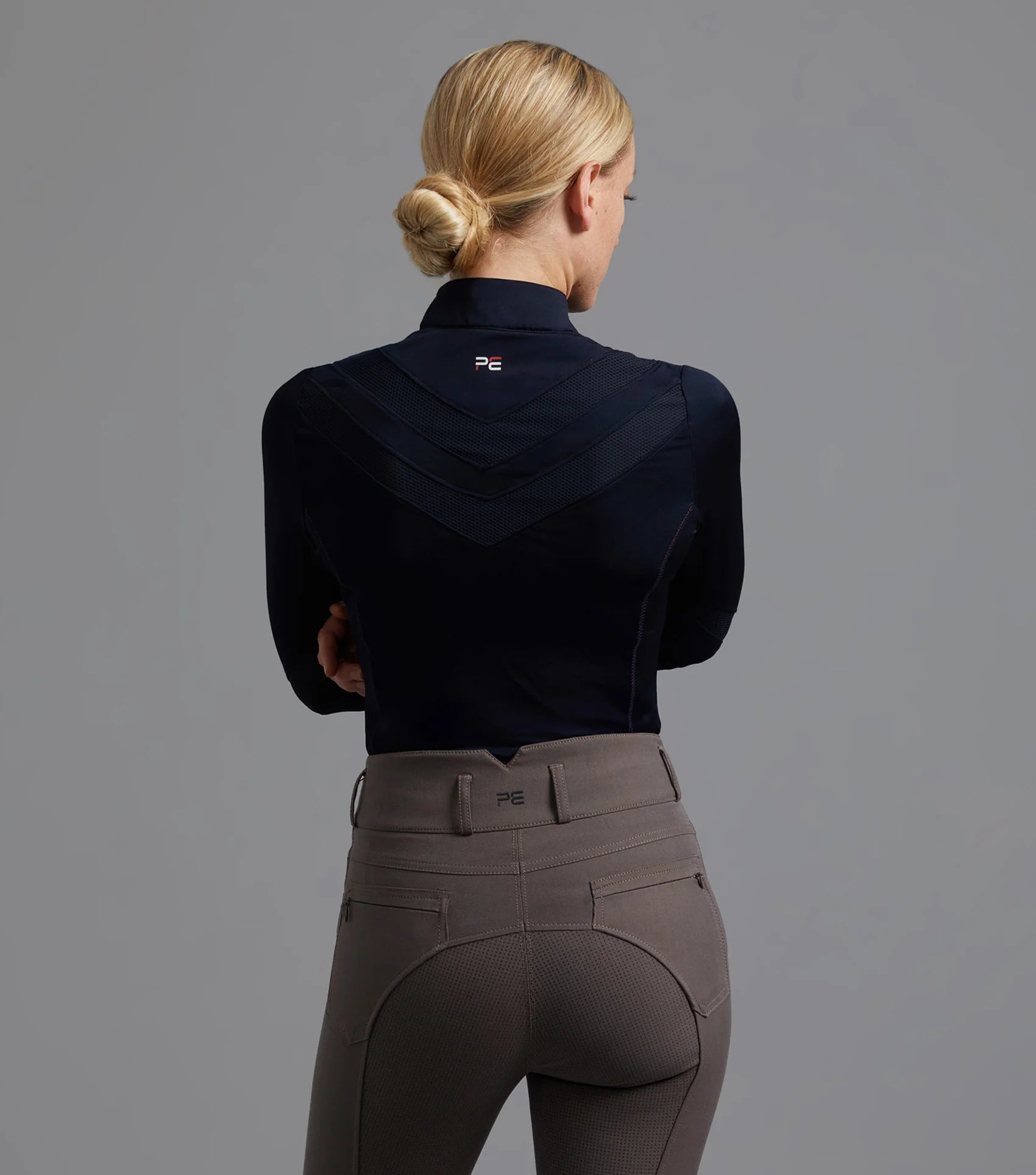 Woman in Premier Equine Arclos Riding Top - Navy Technical Long Sleeve