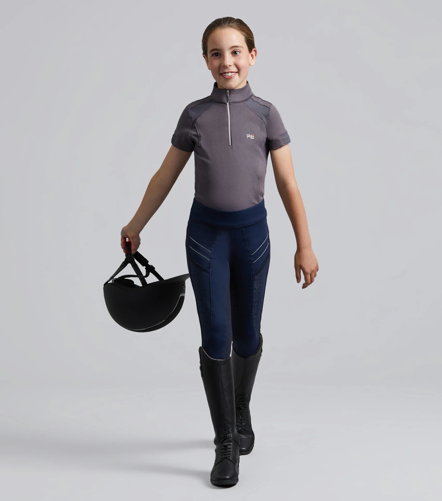 Girl in Premier Equine Navy Riding Tights: Gel Full Seat Equestrian Apparel for Kids, Horse Riding Fashion.