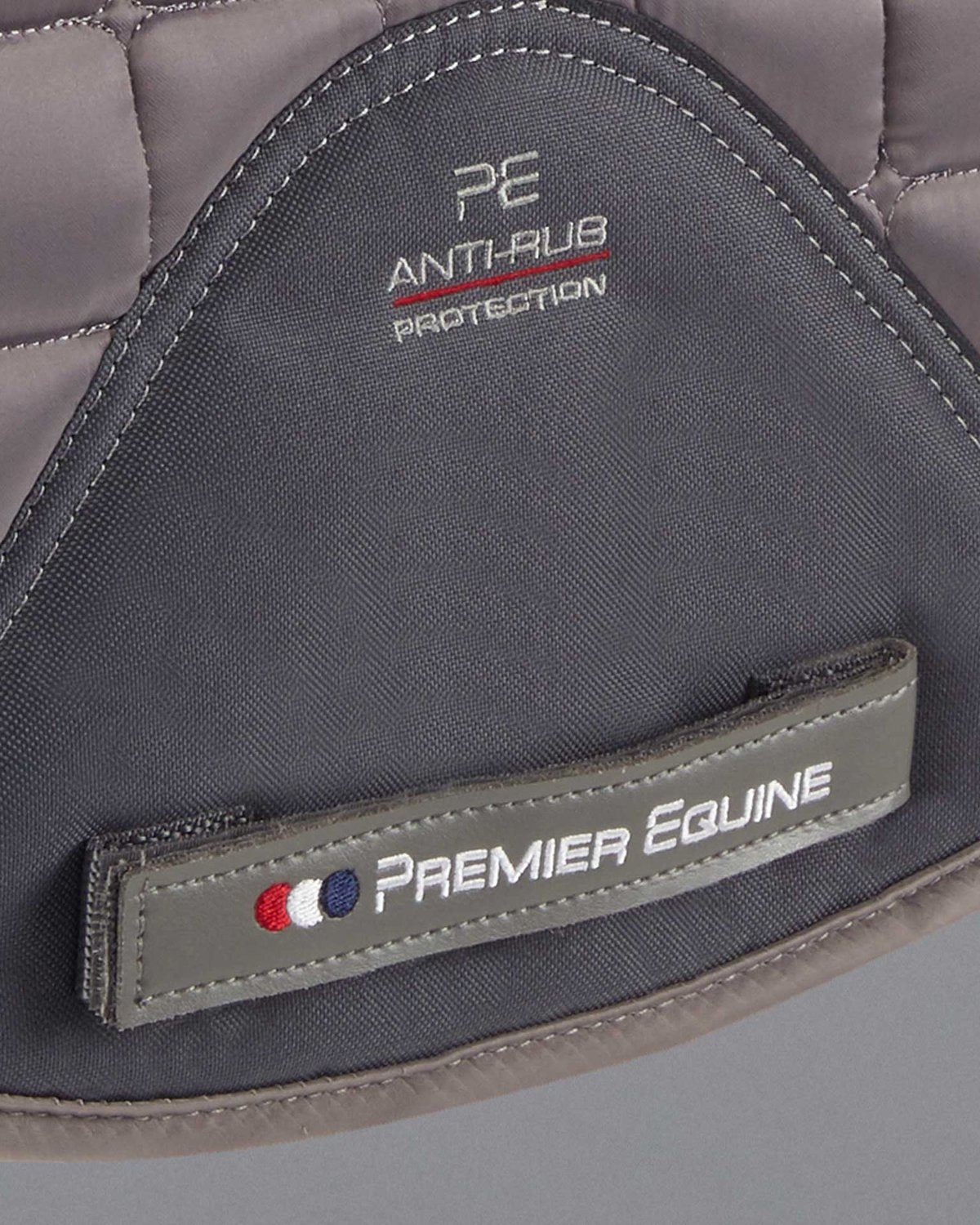 Premier Equine Atlantis Dressage Saddle Pad: Grey & Black Wool Anti-Rub Protection. Close-up of equestrian equipment.