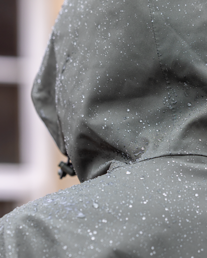 EQUIDRY Women's Storm Smock in Black Forest Green: Waterproof Hoodie from Equiflair with hood and rain drops.