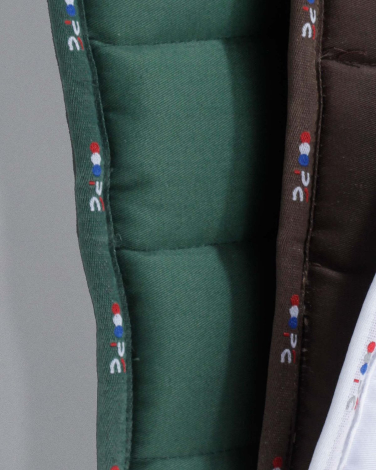 PREMIER EQUINE BUSTER Reversible Saddle Pad Green Close-up: Durable cotton, logo trim, reversible design.