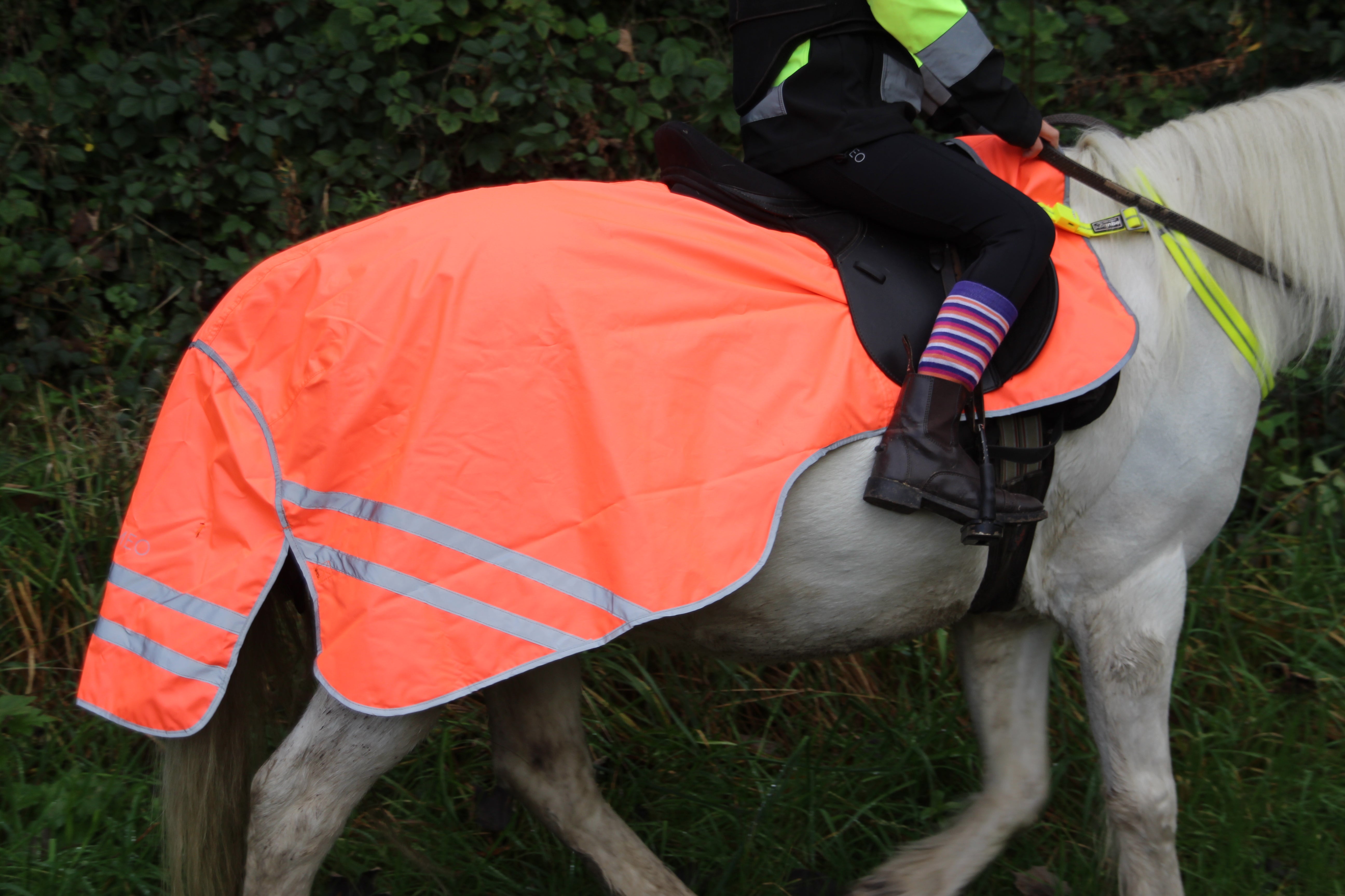 Horse riding with hi-viz reflective safety exercise sheet by Equiflair. Reflective details, waterproof & enhanced rider visibility