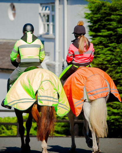 Two horses with riders in CAMEO hi-viz safety jackets. Riding safely with Equiflair's hi-visibility gear.