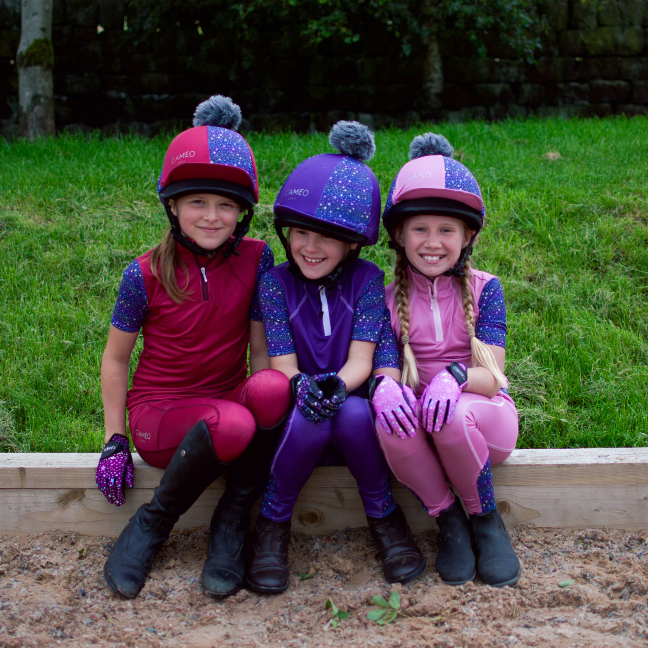 Three girls in Cameo Junior Zest riding tights and helmets by Equiflair. Equestrian apparel for kids.