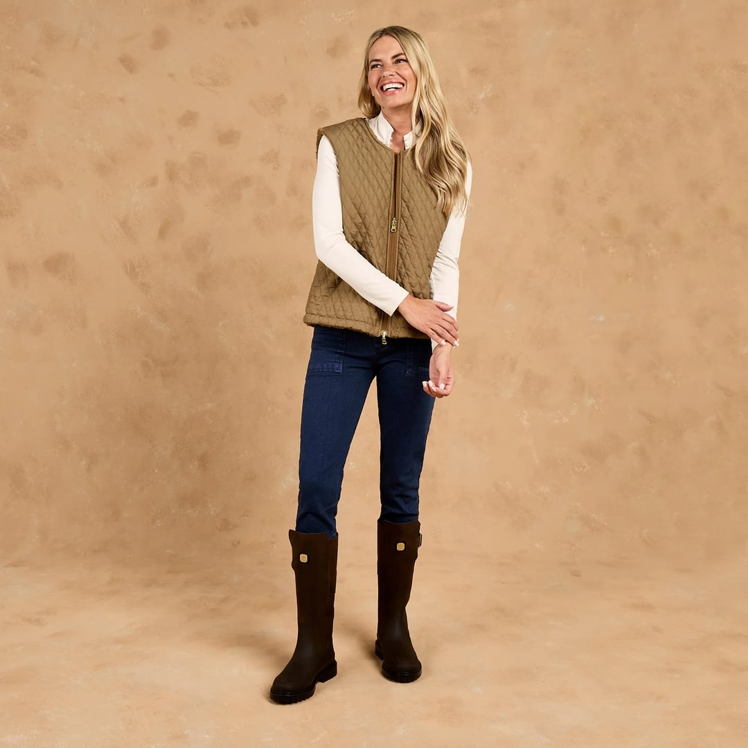 Woman wearing TOGGI CARNEY reversible quilted sherpa fleece gilet vest in brown