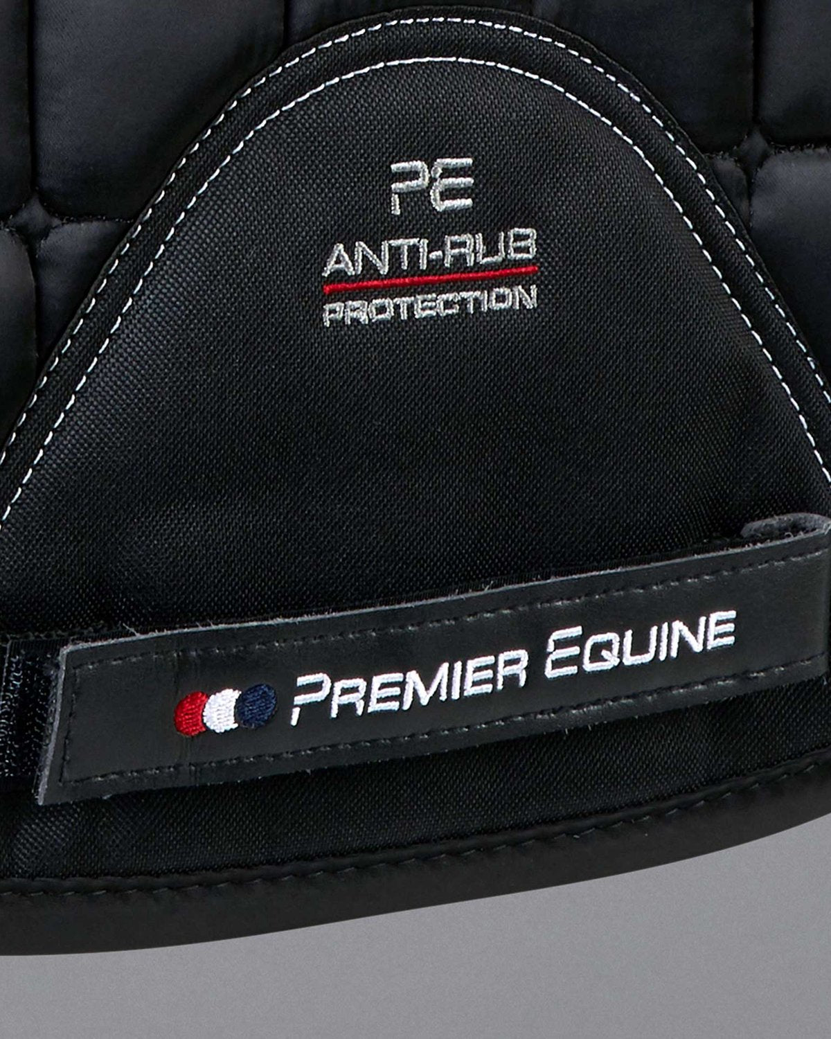Premier Equine Anti-Rub Merino Wool Saddle Pad: Black quilted GP/Jump square with white stitching and PE branding.