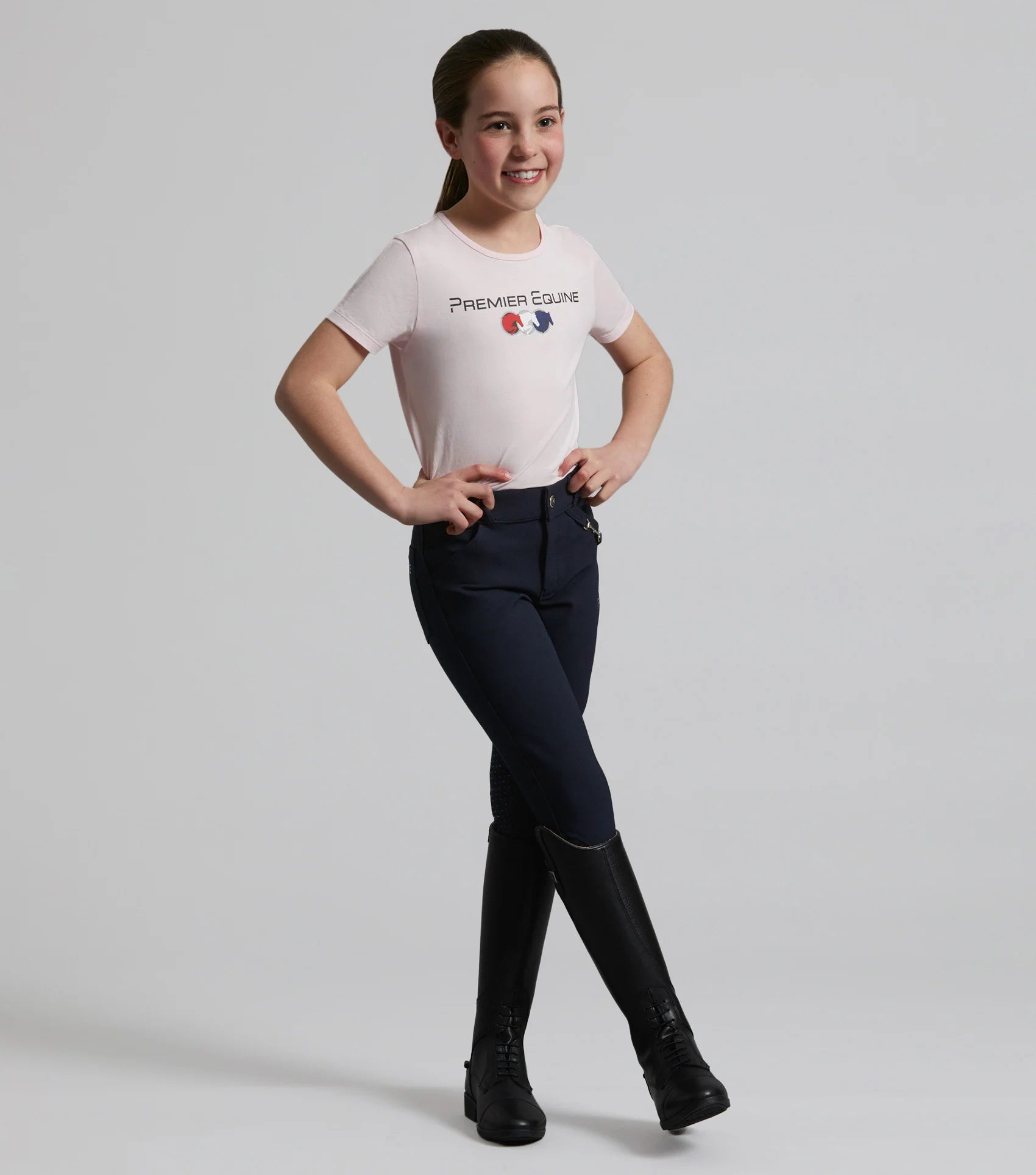 Girl wearing Premier Equine pink cotton riding t-shirt. Equestrian apparel for girls. Equestrian fashion.