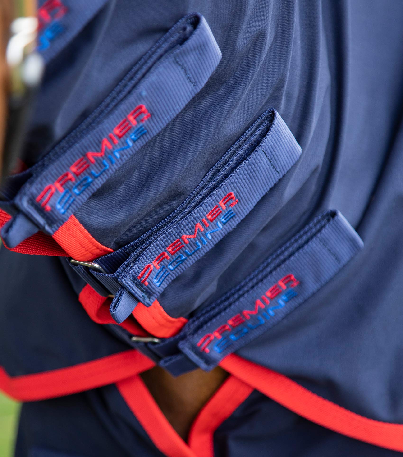 Premier Equine Navy Horse Stable Sheet: Close-up of straps and red trim detail.