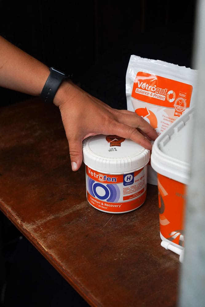 Vetrofen Healthy Horse Supplement: Hand opening jar of joint support by Equiflair. Animal health, comfort & recovery.