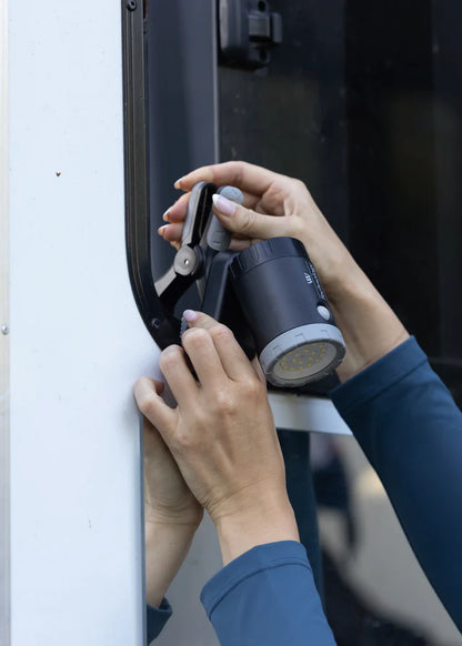 WOOF WEAR Multi-Mount LED Work Light in Equestrian Setting: Hands Attaching Light for Stable or Trailer Use.