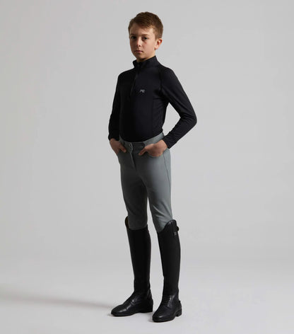 Boy in Premier Equine Grey Derby Riding Breeches, black top & boots. Equestrian apparel for young riders. Equiflair product image.