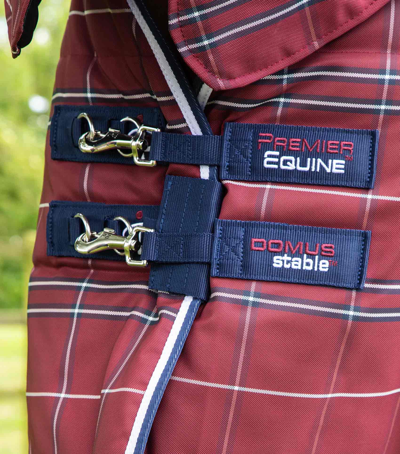 Premier Equine Domus 200g Stable Rug - Burgundy Check closeup. Detailing the Premier Equine brand details on the rug's closures.