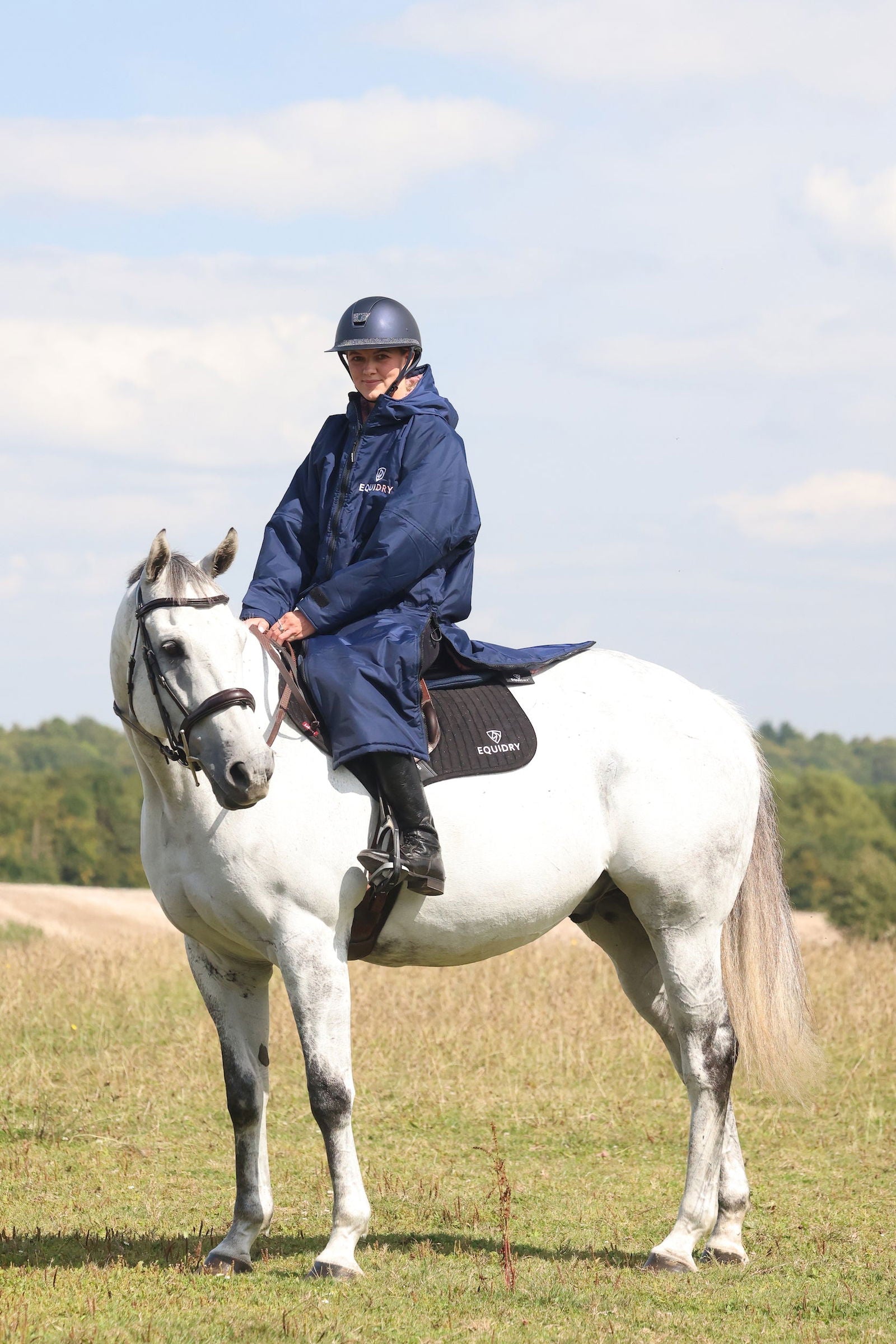 EQUIDRY waterproof horse riding raincoat All Rounder Original thick fleece Women's Navy/Pale Pink side view rider on horse