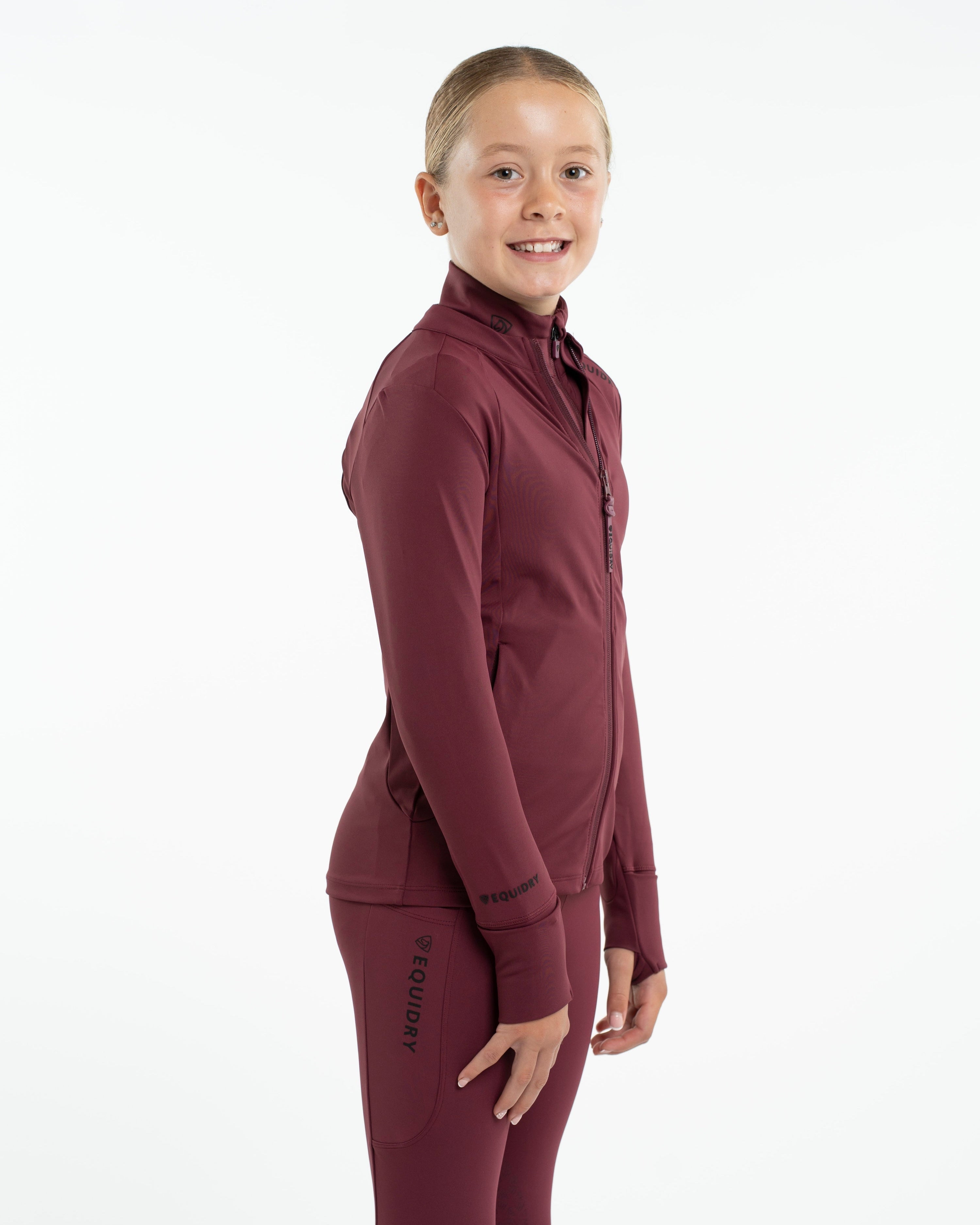 EQUIDRY Children's Water Repellent Zip Up Top - Plum. Girl wearing equestrian apparel for riding & outdoor activities.