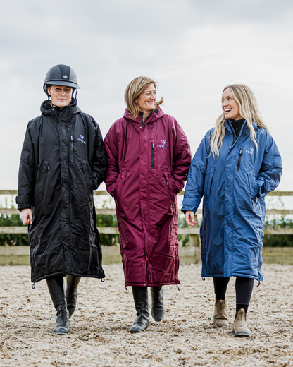 Equidry Evolution Riding Coats: Women in black, burgundy & blue fleece-lined waterproof equestrian coats on a farm track.