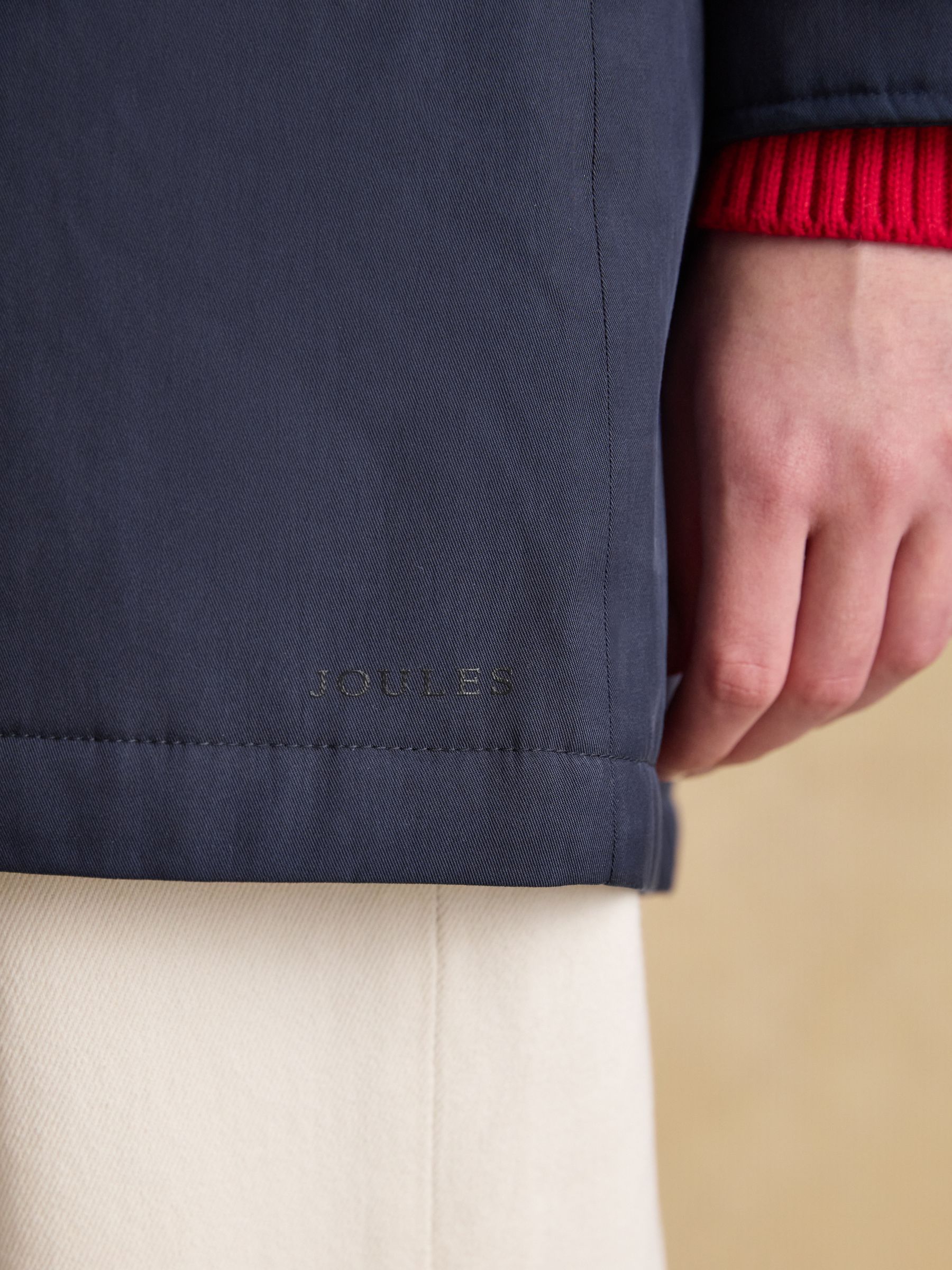 Joules Portwell navy fleece-lined waterproof raincoat detail with embroidered logo.