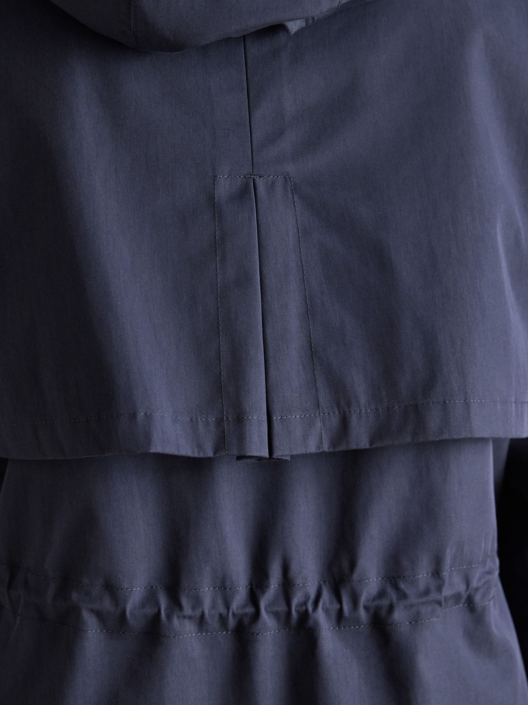 Joules women's navy fleece-lined waterproof raincoat with adjustable hood and taped seams.