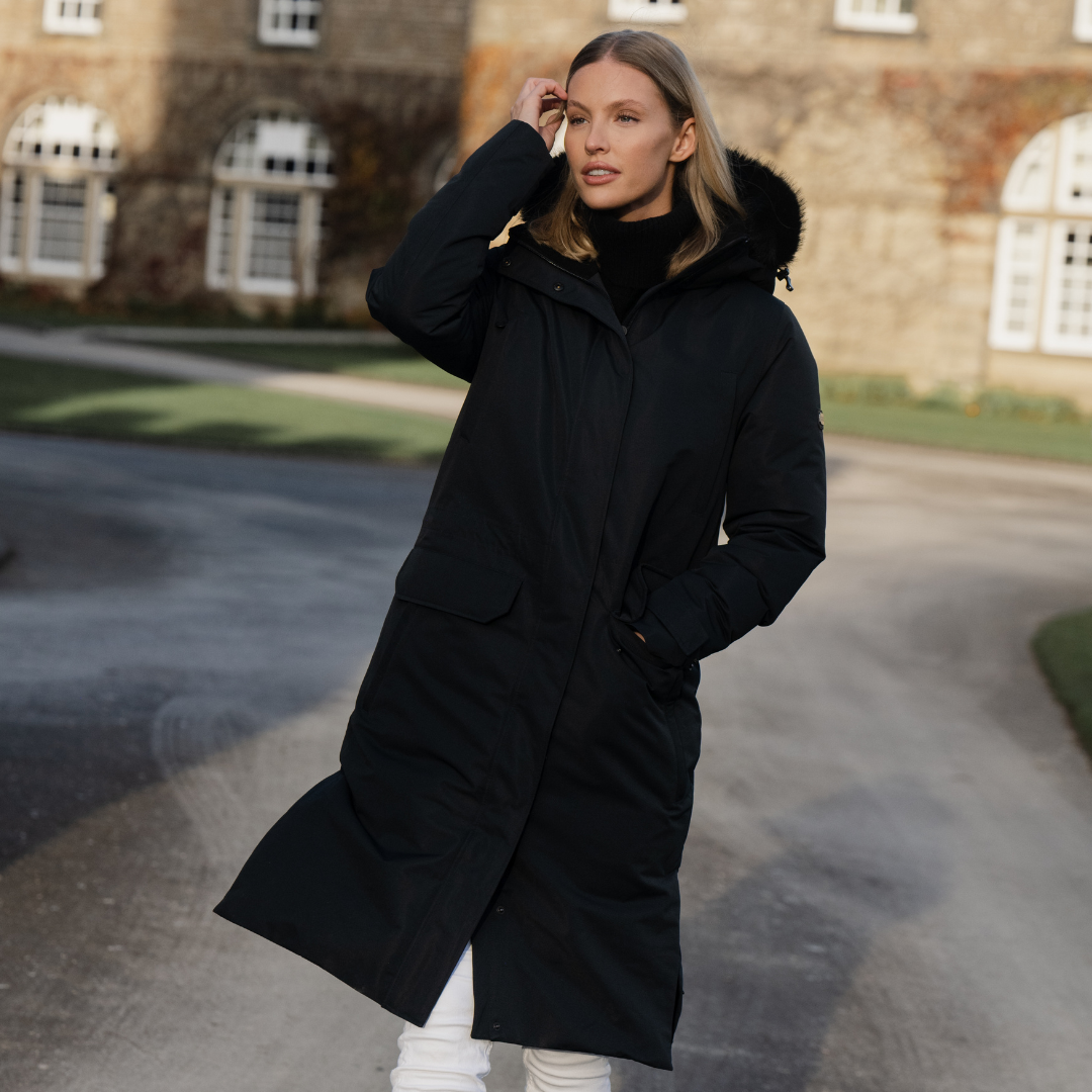 Woman wearing a black TOGGI FIELDSTON waterproof long winter coat with faux fur hood