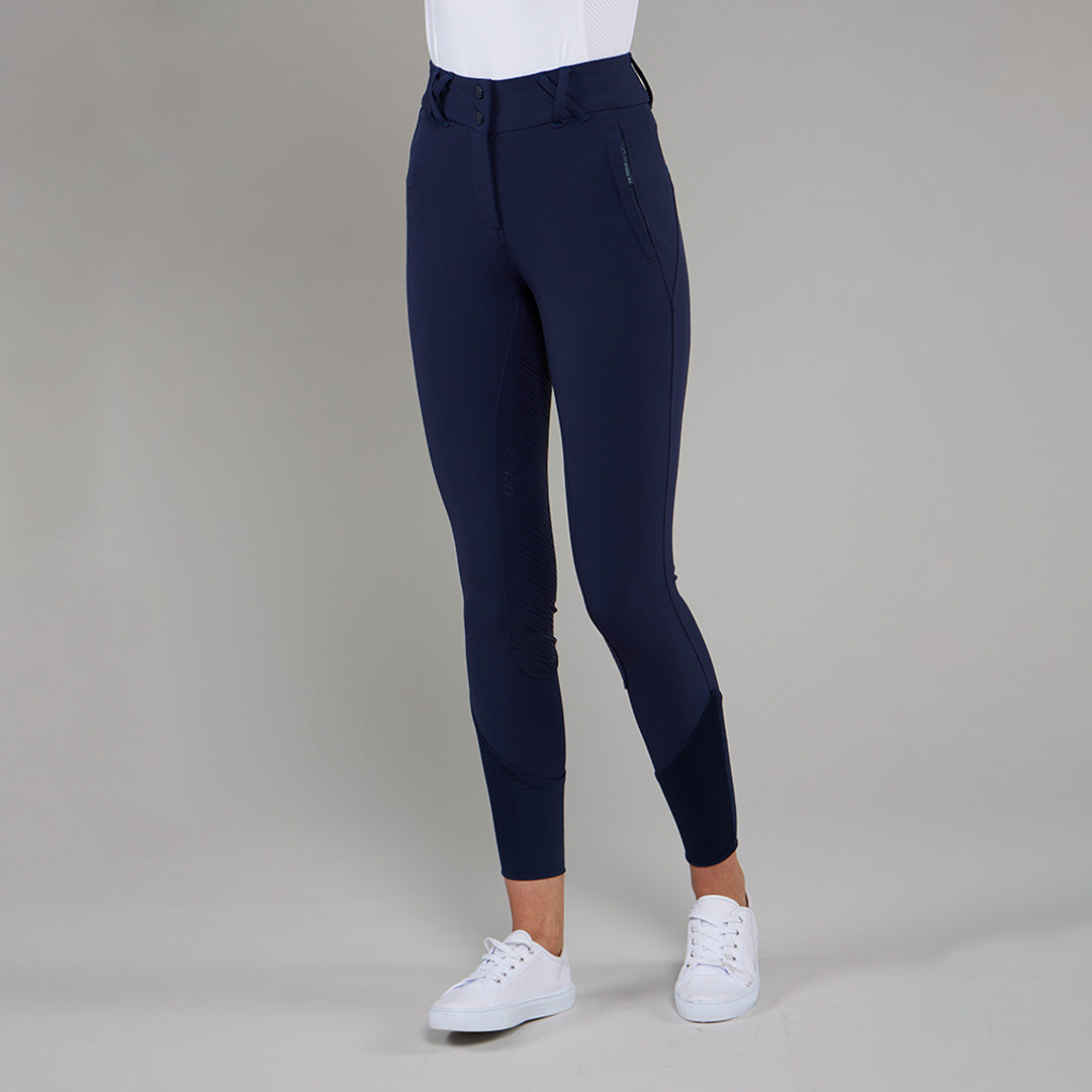 Navy TOGGI FLEXI women's full seat riding breeches with silicone grip and white sneakers.