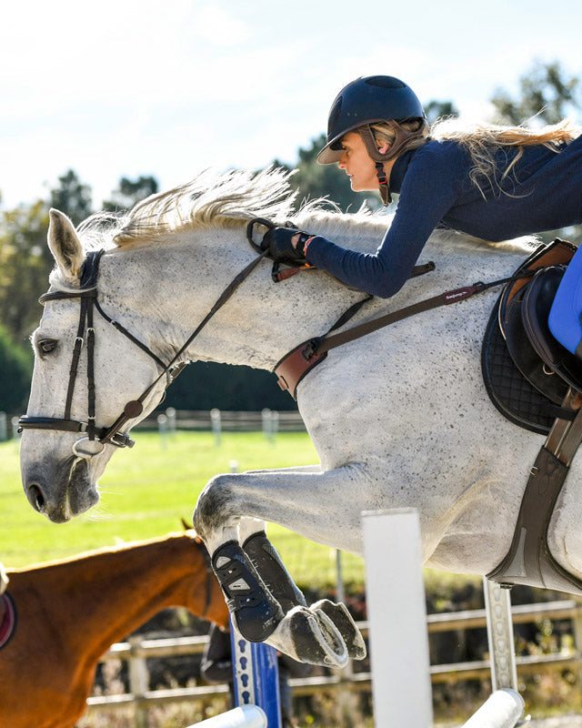 Horse jumping with rider using Freejump Collar. Equestrian sport, horse training, show jumping equipment by Freejump
