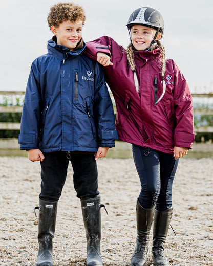 Shortie Child's Oversized Short Waterproof blouson style Riding Jacket Thin Fleece Lining Stowaway Hood in plum and navy in arena