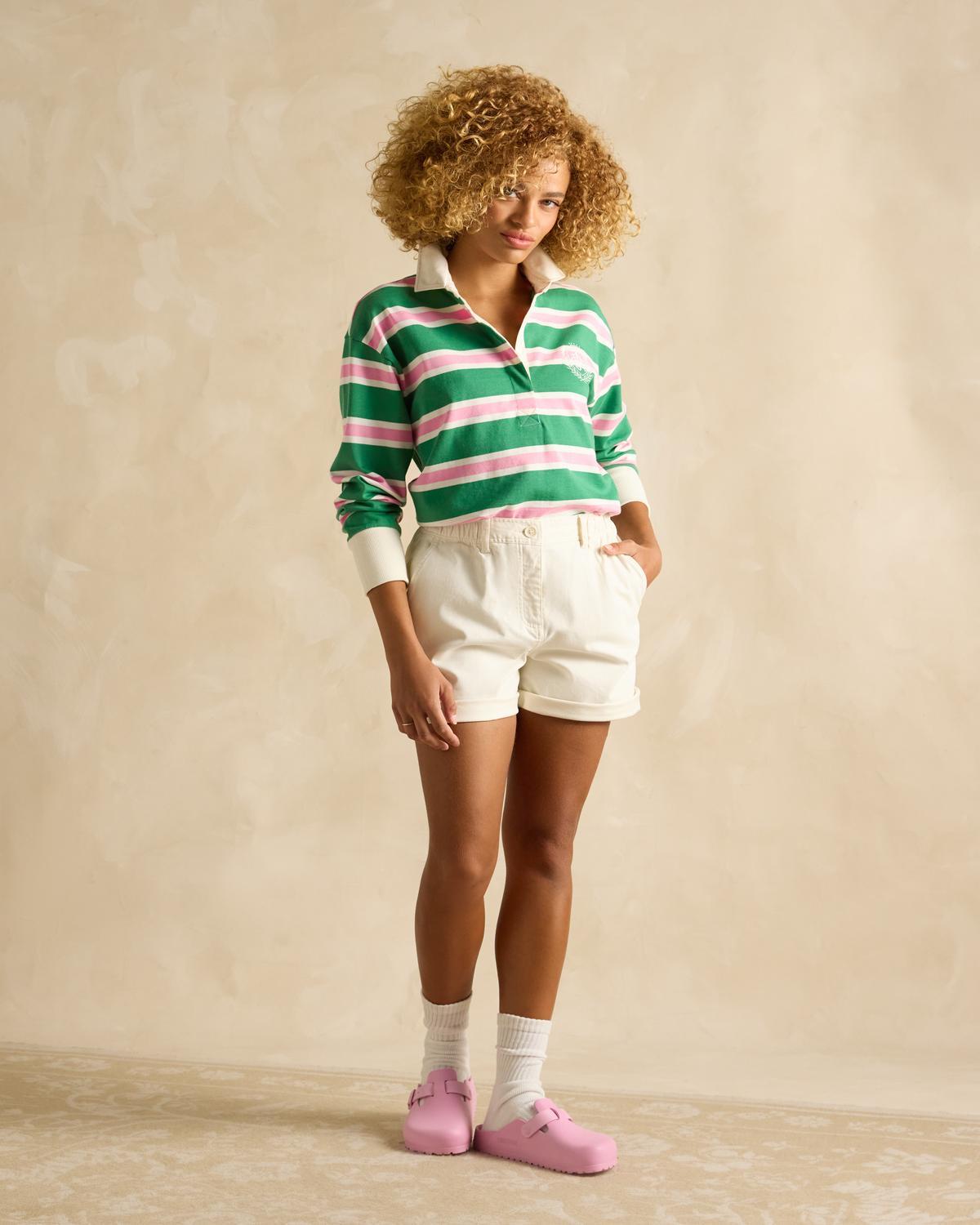 JOULES LARA Green Multi Rugby Shirt: Stylish Woman in Striped Top, White Shorts, Pink Clogs - Equiflair Fashion