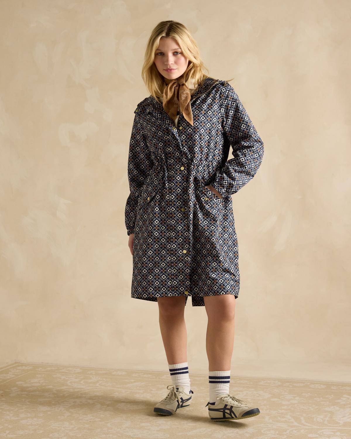 JOULES HOLKHAM Navy Waterproof Packable Raincoat: Stylish women's raincoat, recycled polyester, full shot, model, patterned, autumn fashion.