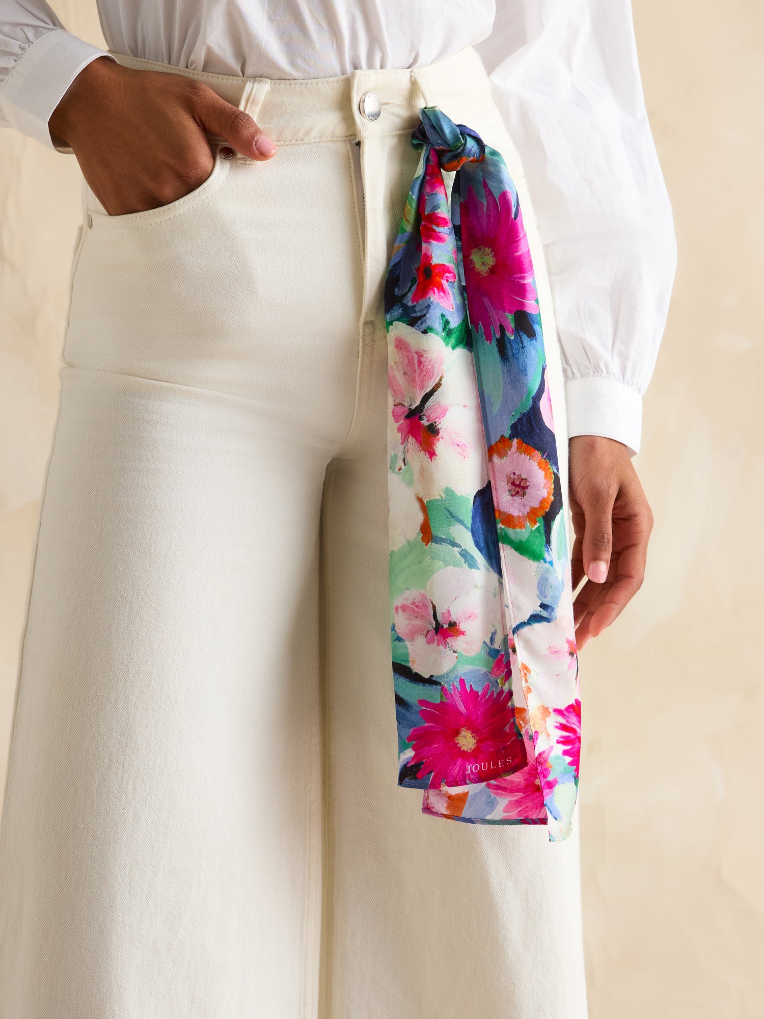 JOULES Highgrove Silk Scarf Floral Print: Woman wearing a colorful floral scarf as a belt in white pants