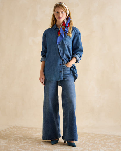 Joules Scarf Blue/Neutral: Woman wearing printed square scarf as headscarf, styled with denim shirt and wide-leg jeans.